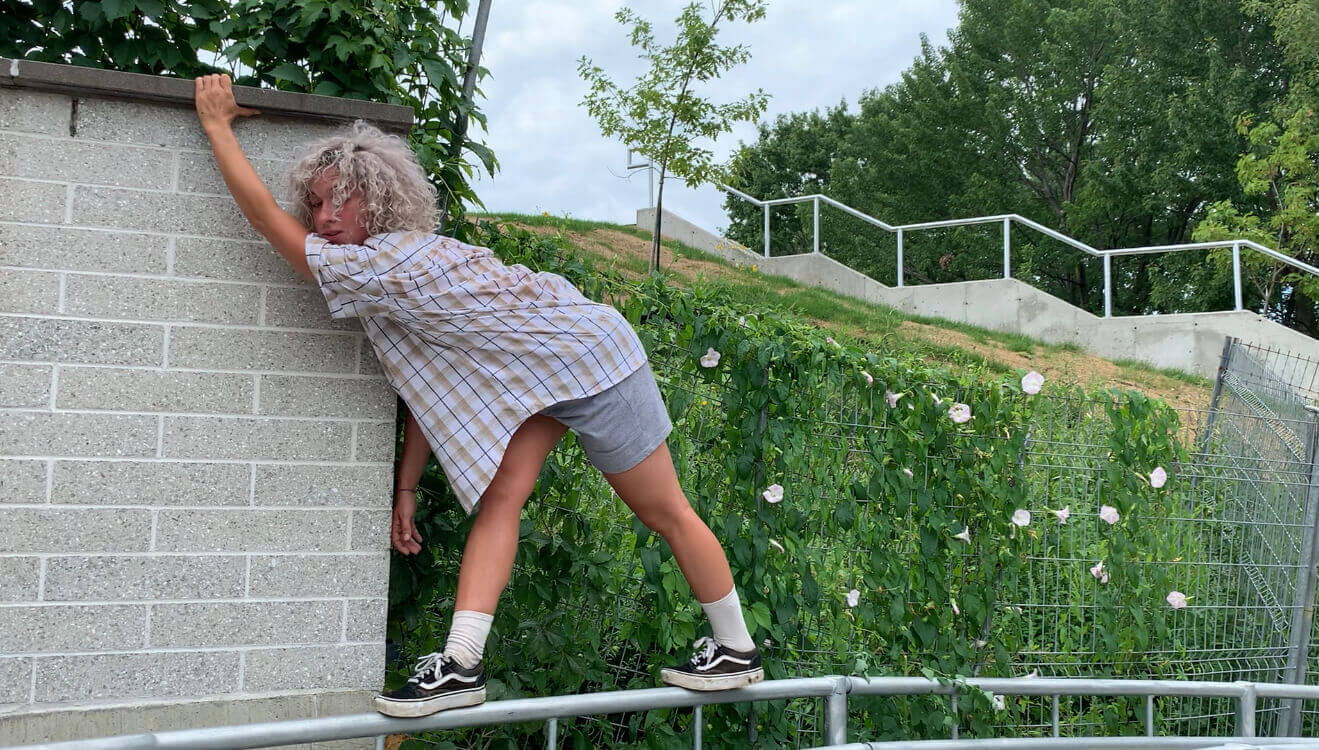 L'interprète en danse Maude Laurin-Beaulieu s'accroche à un mur, en équilibre sur une rampe.