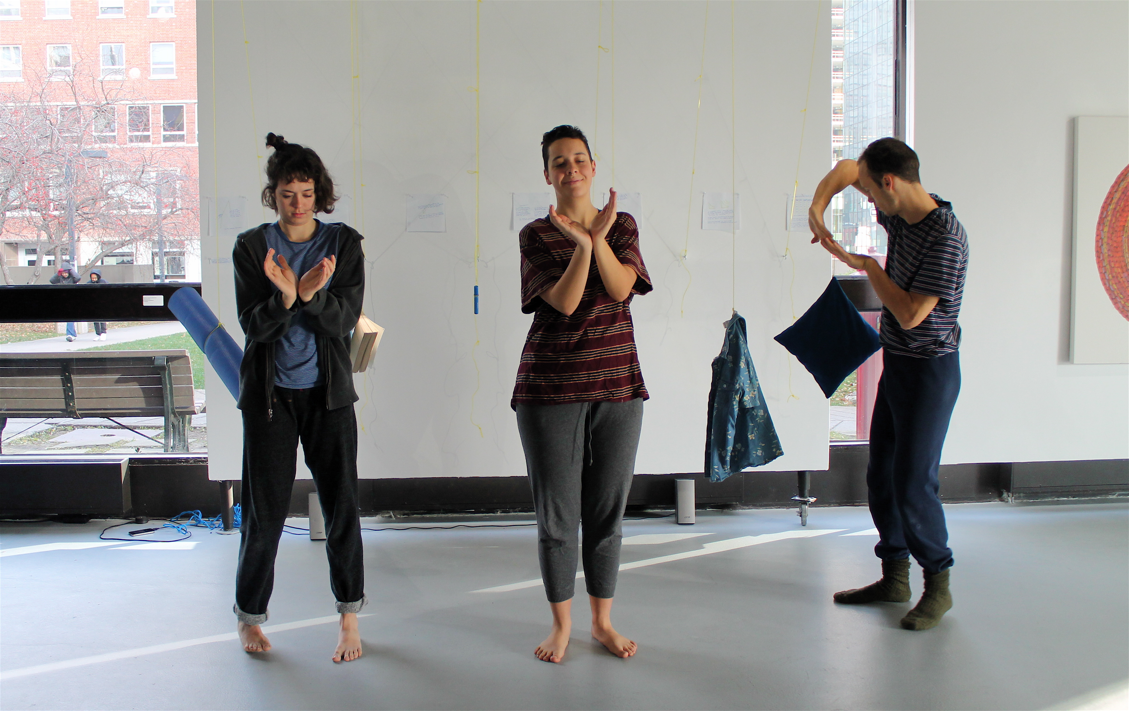 Three dancers making shapes with their arms